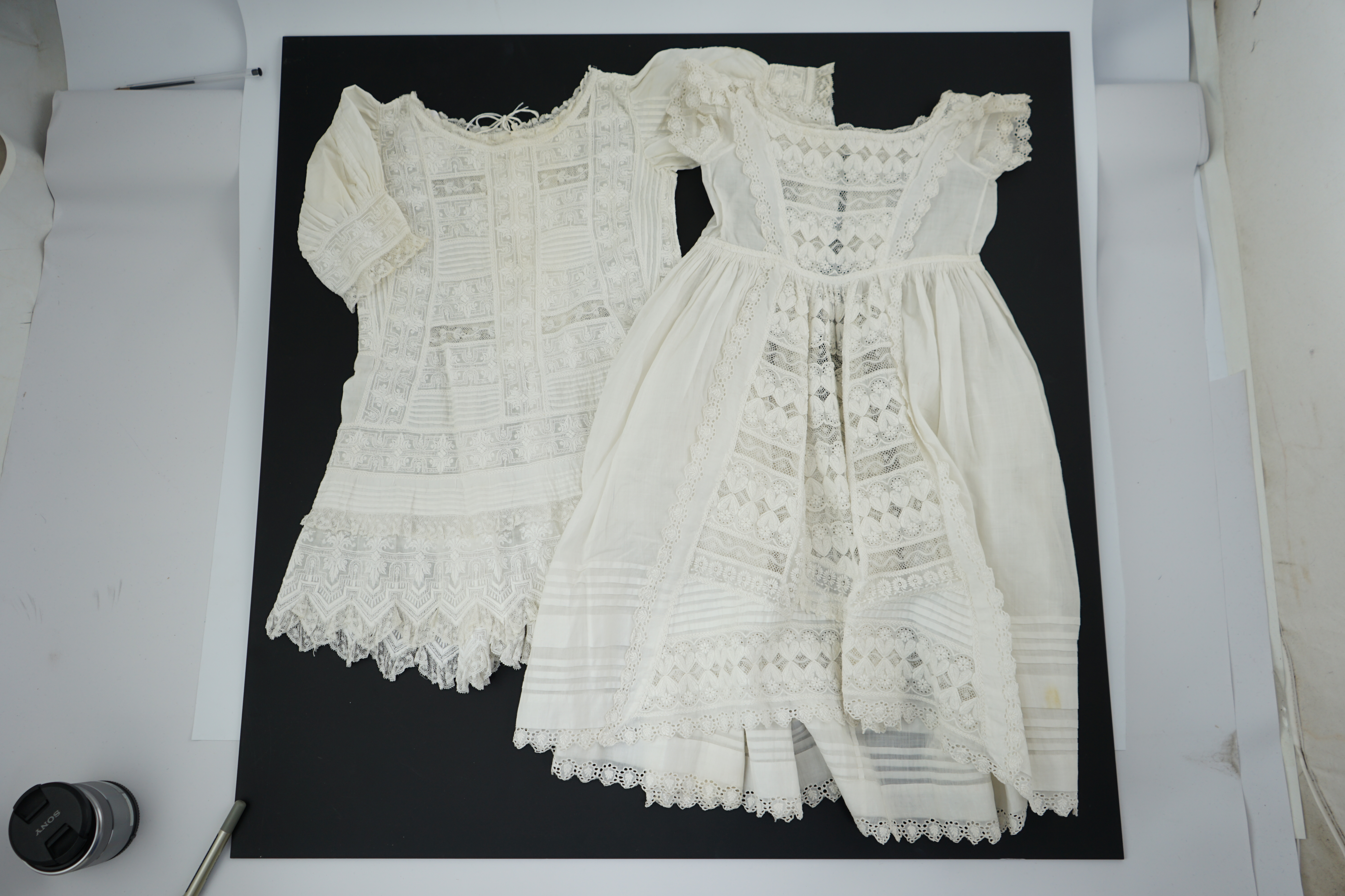 Two unusual 19th century intricately white worked children’s dresses, one hand worked with fine panels of white work, feather stitching and tucking, edged and inserted with hand made Valenciennes lace, the other worked i